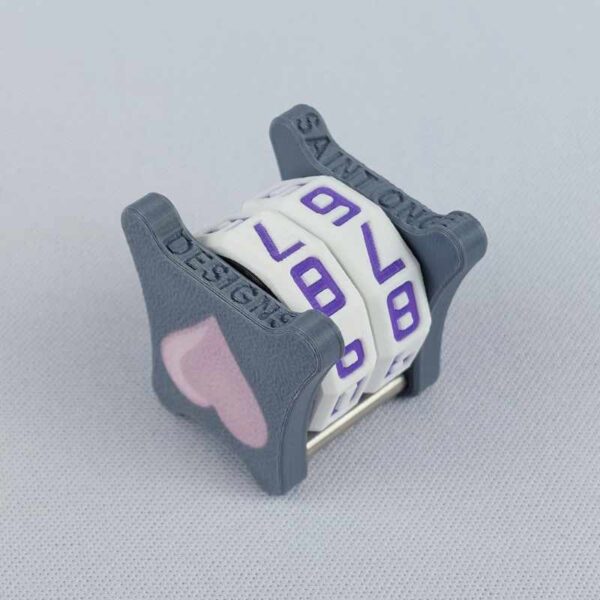 The NC-2 number counter viewed from an isometric angle showing the bottom and side 2 pink heart. The version shown has a dark gray base and a pink heart in the middle on both sides 1 and 2.