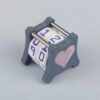 The NC-2 number counter viewed from an isometric angle showing the top dials and side 2 heart. The version shown has a dark gray base and a pink heart in the middle on both sides 1 and 2.